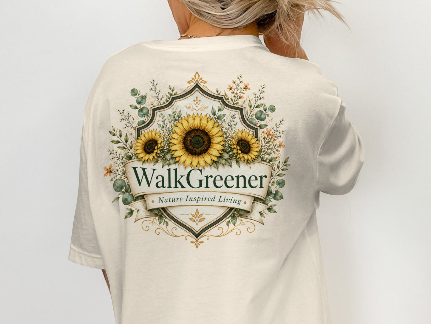 Cream t-shirt with a floral crest featuring sunflowers, eucalyptus, and the text "WalkGreener Nature Inspired Living".