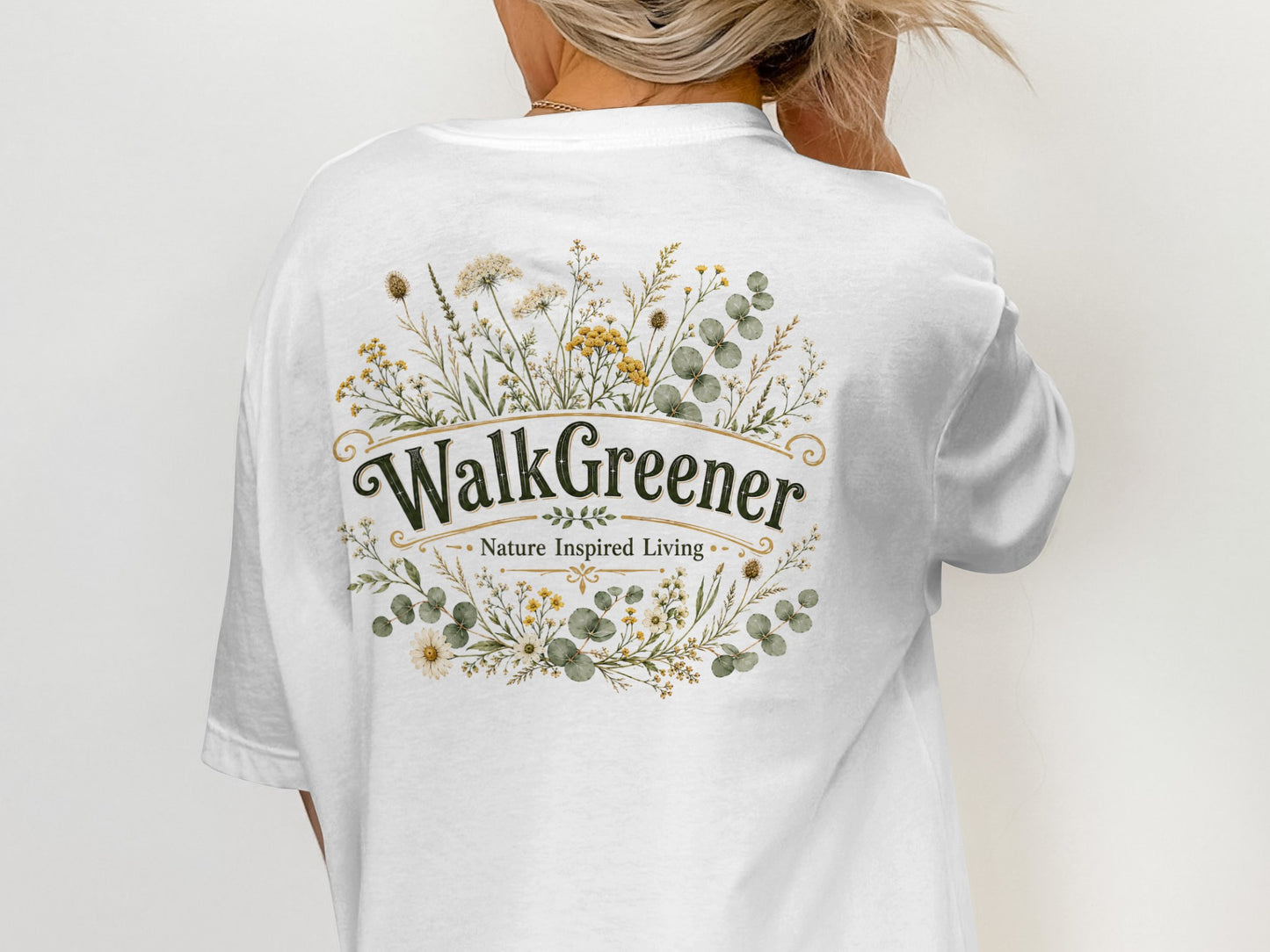 White t-shirt with a botanical floral wreath design and "WalkGreener Nature Inspired Living" text.