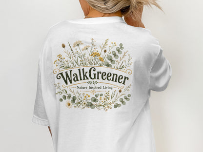 White t-shirt with a botanical floral wreath design and "WalkGreener Nature Inspired Living" text.