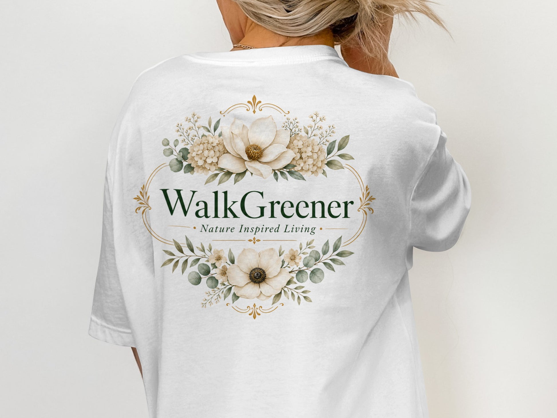 White t-shirt with oval floral design and text "WalkGreener Nature Inspired Living."