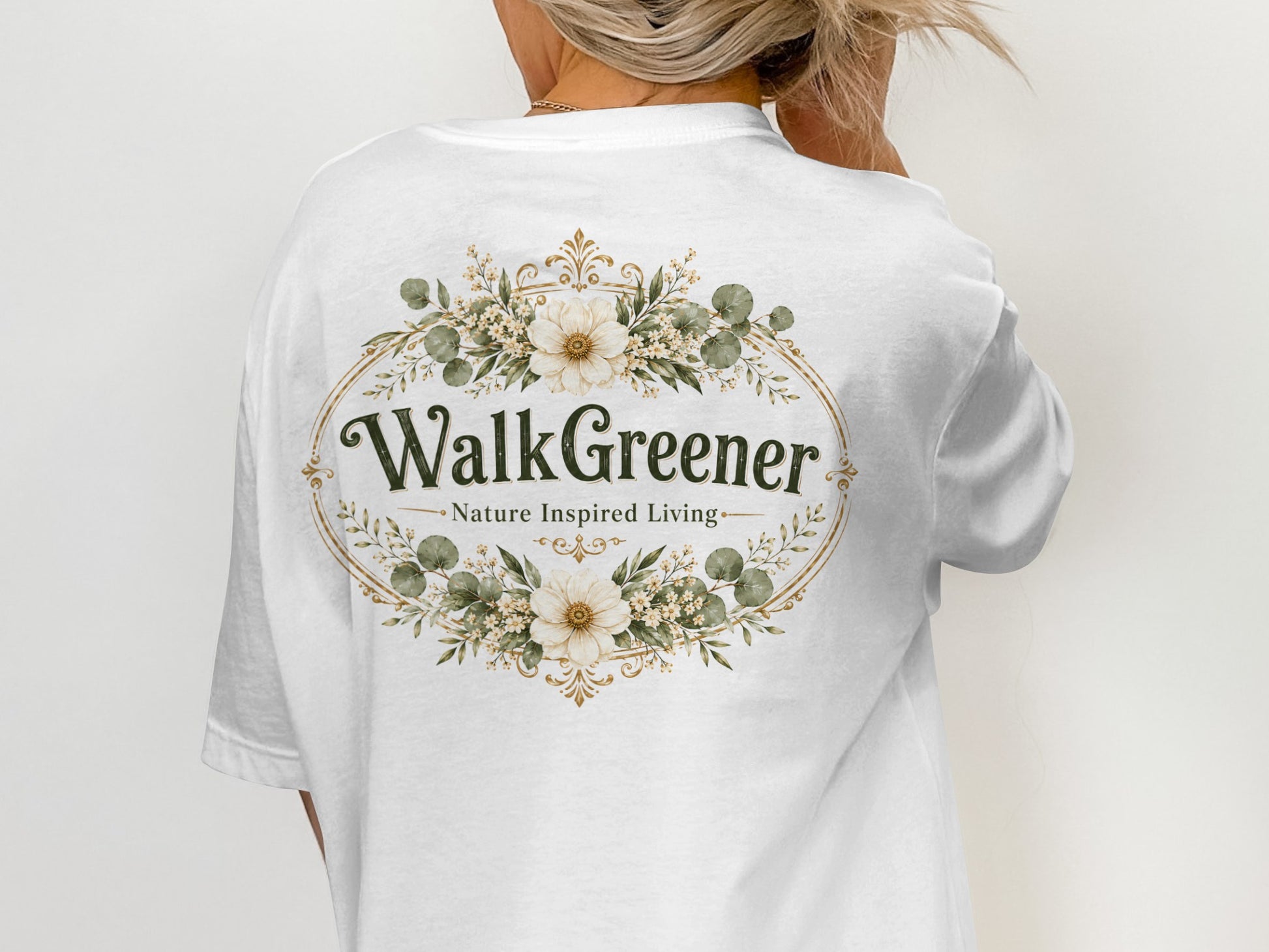 White t-shirt with a floral oval design featuring "WalkGreener - Nature Inspired Living" text.