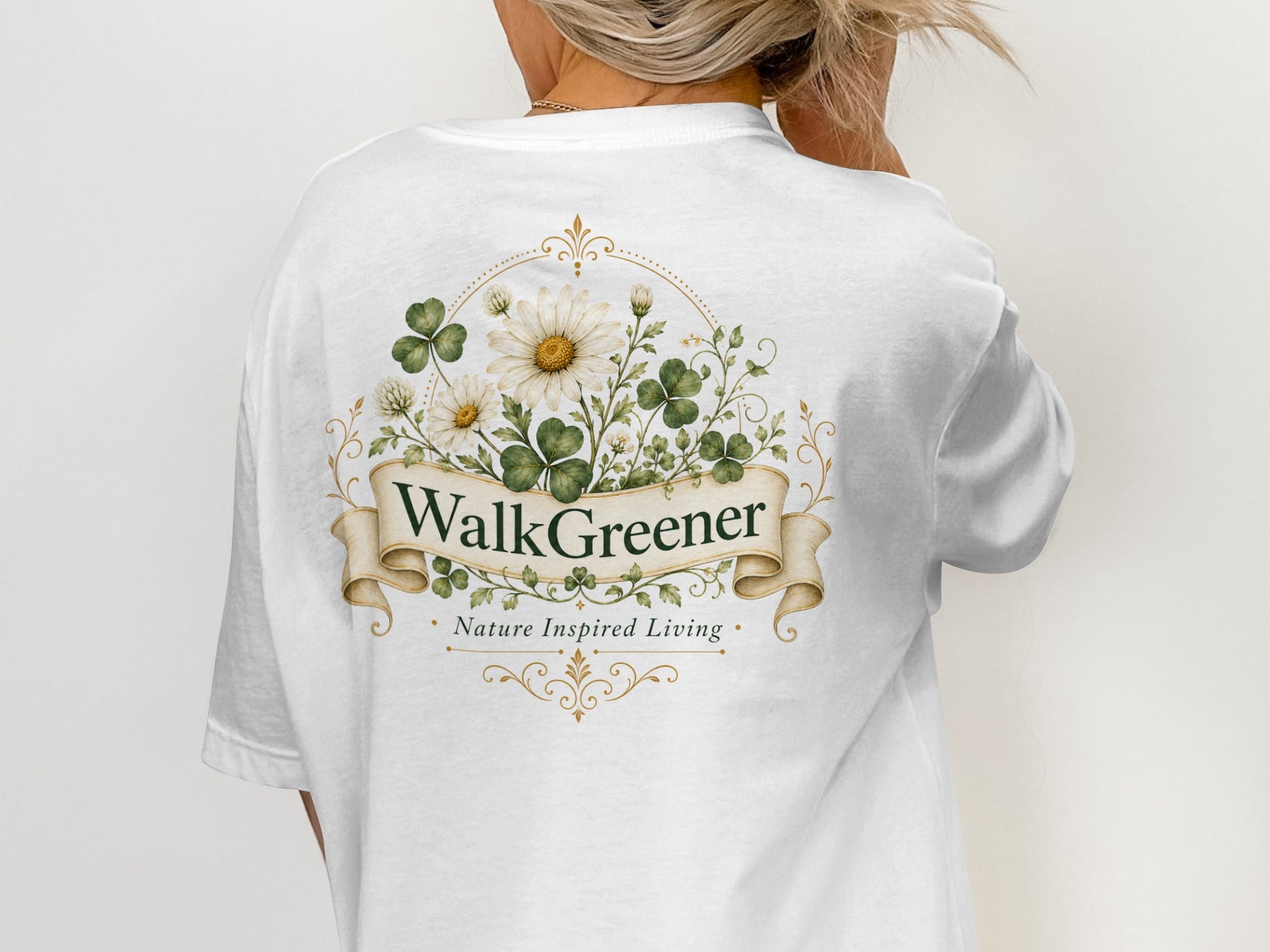 White t-shirt with a circular floral design featuring daisies and clover leaves with "WalkGreener" and "Nature Inspired Living" text.