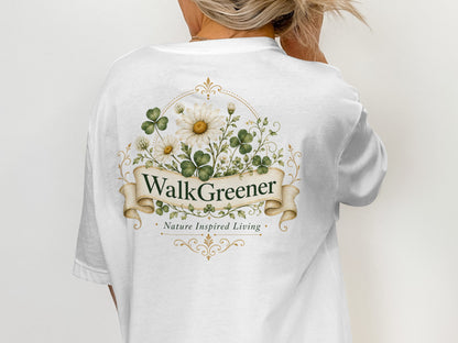 White t-shirt with a circular floral design featuring daisies and clover leaves with "WalkGreener" and "Nature Inspired Living" text.