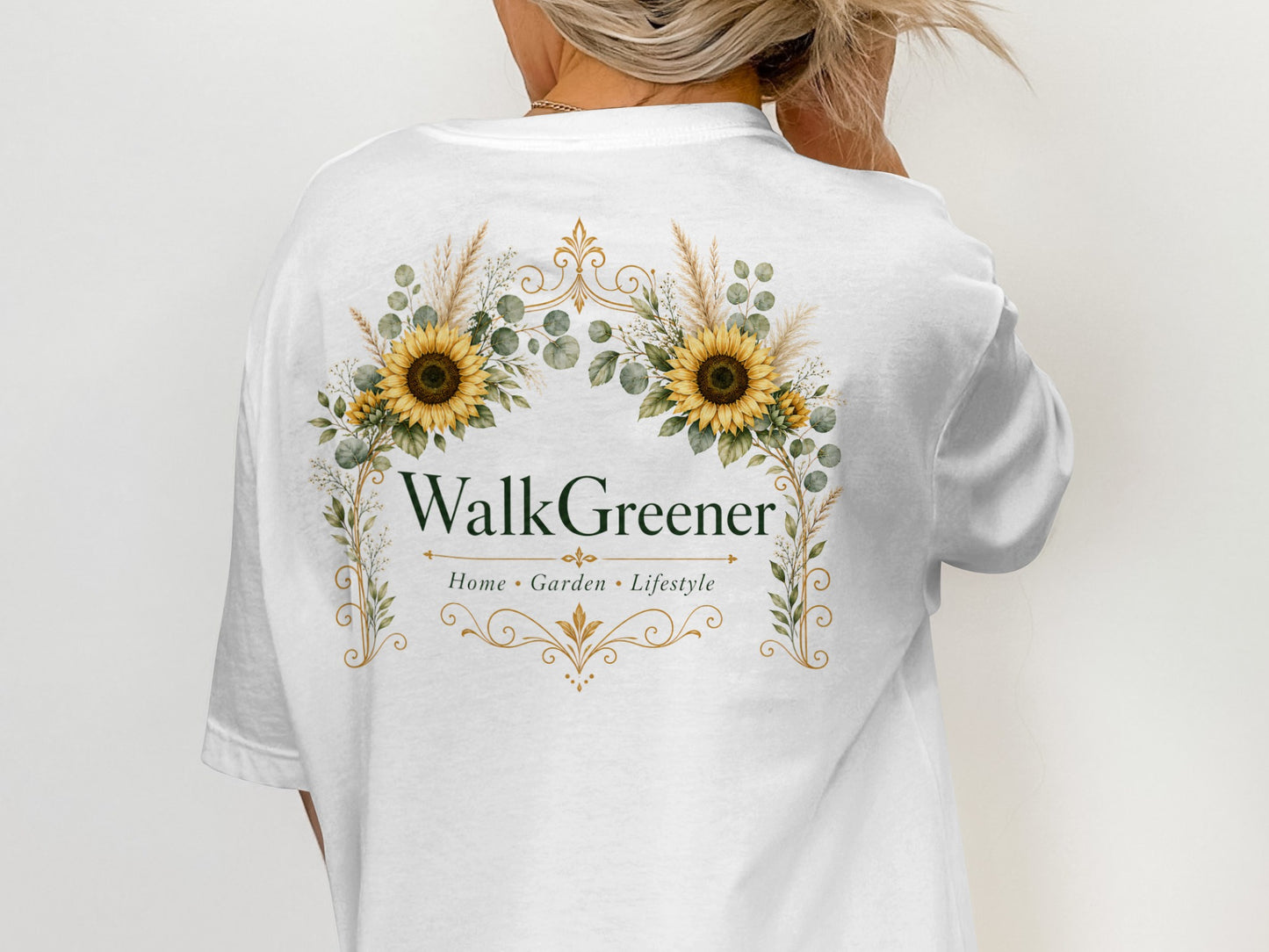 White t-shirt with a floral emblem featuring sunflowers and the text "WalkGreener Home Garden Lifestyle".