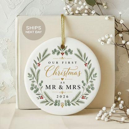 Round ornament reading "Our First Christmas as Mr & Mrs 2026" with floral design.