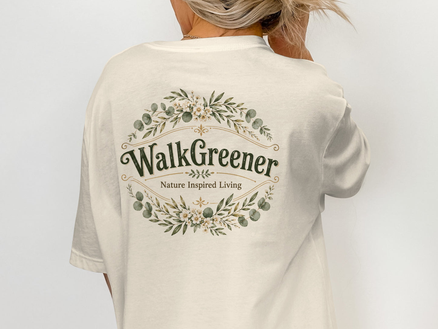 Cream t-shirt with a floral wreath graphic containing "WalkGreener Nature Inspired Living".