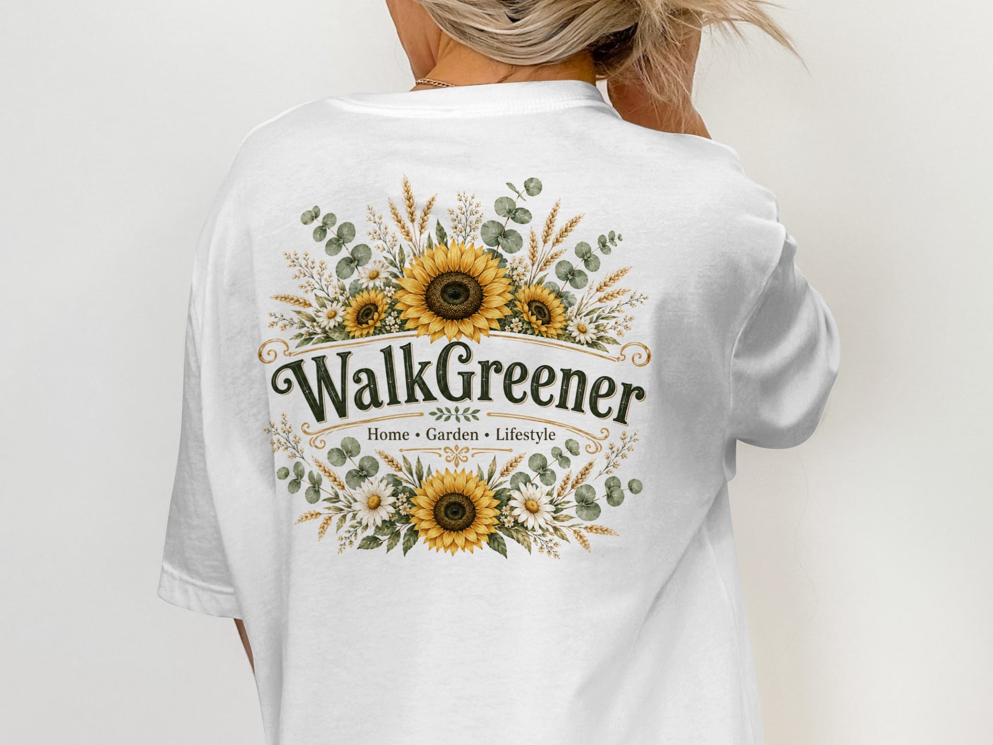 White t-shirt with "WalkGreener" and floral design featuring sunflowers, daisies, and wheat.