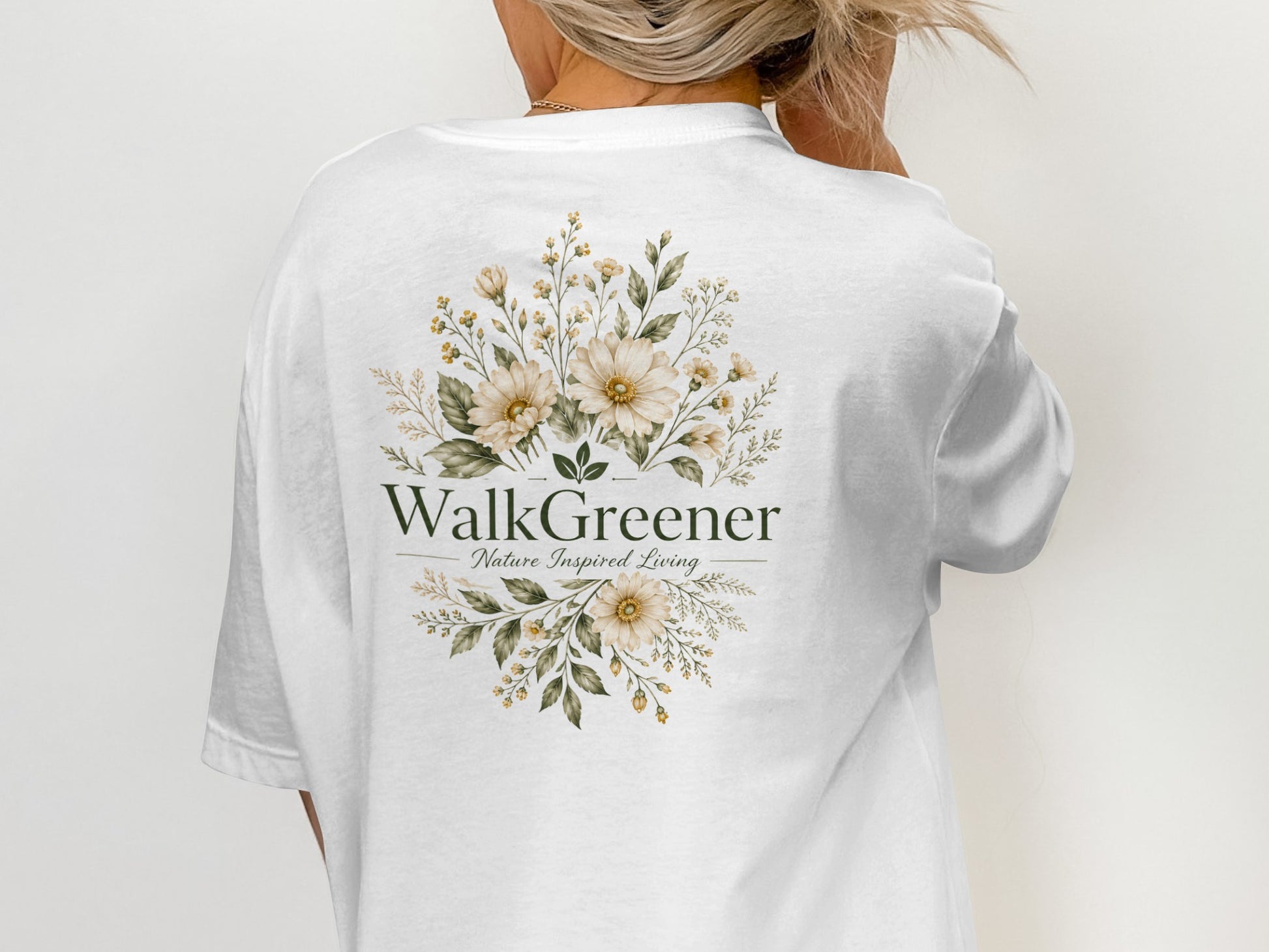 White t-shirt with "WalkGreener Nature Inspired Living" text and floral design.