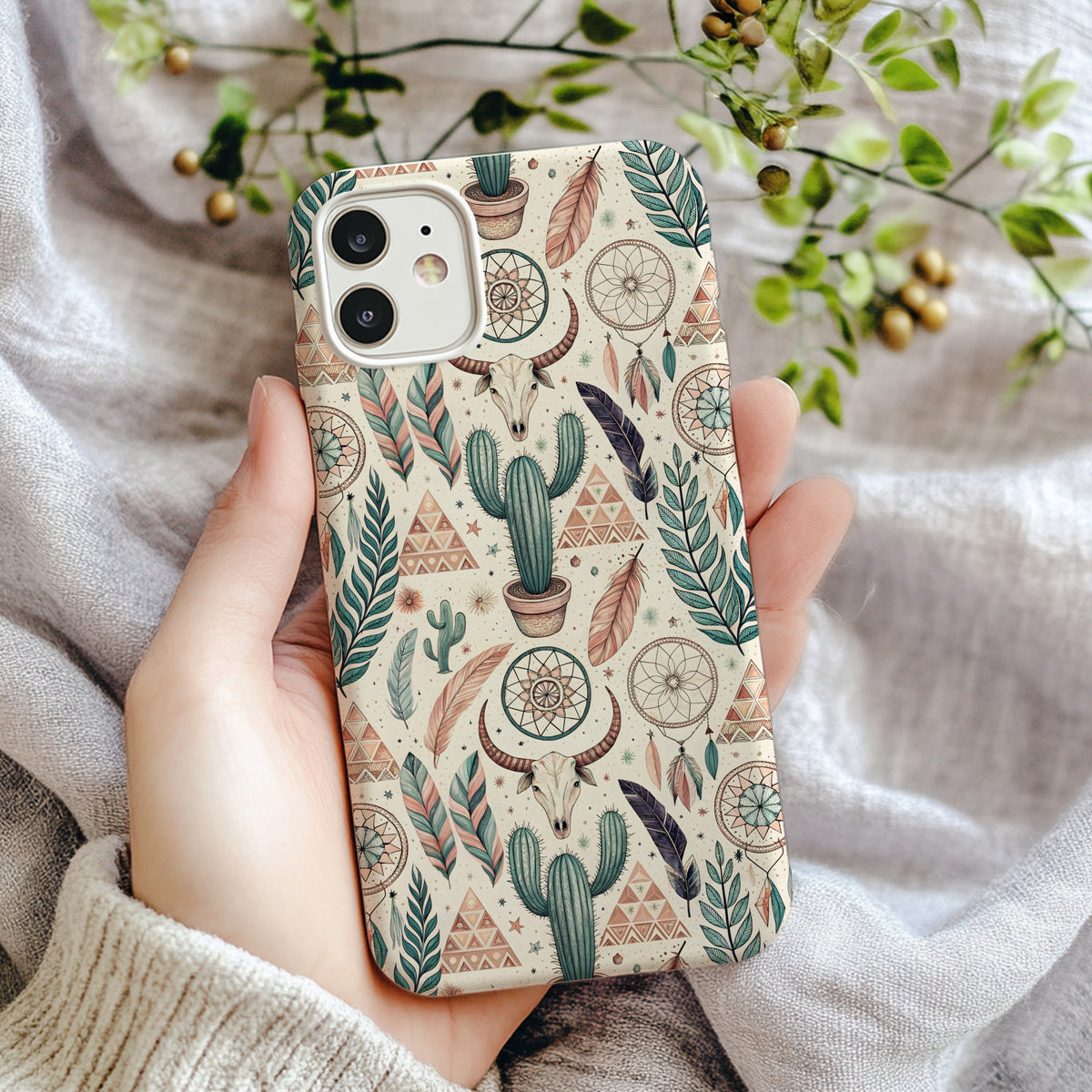 Close-up of a bohemian cactus and dreamcatcher phone case pattern showing hand-drawn cacti, feathers, and mandala dreamcatchers