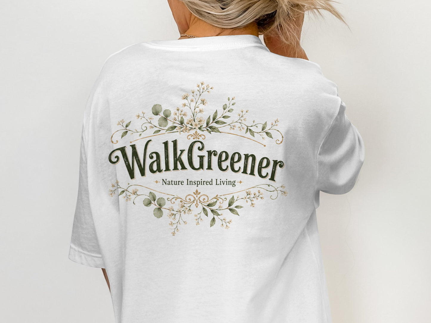 White t-shirt with "WalkGreener Nature Inspired Living" in green text and floral emblem.