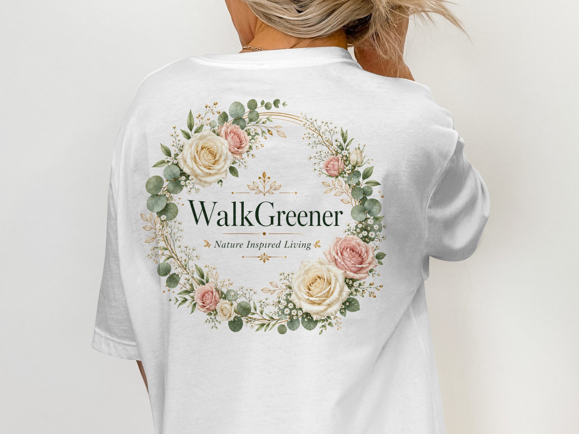 White t-shirt with a floral wreath design and "WalkGreener Nature Inspired Living" text.